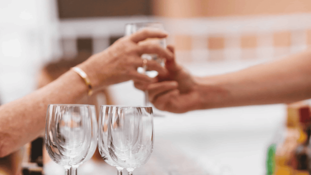 a person handing a glass of water to another person