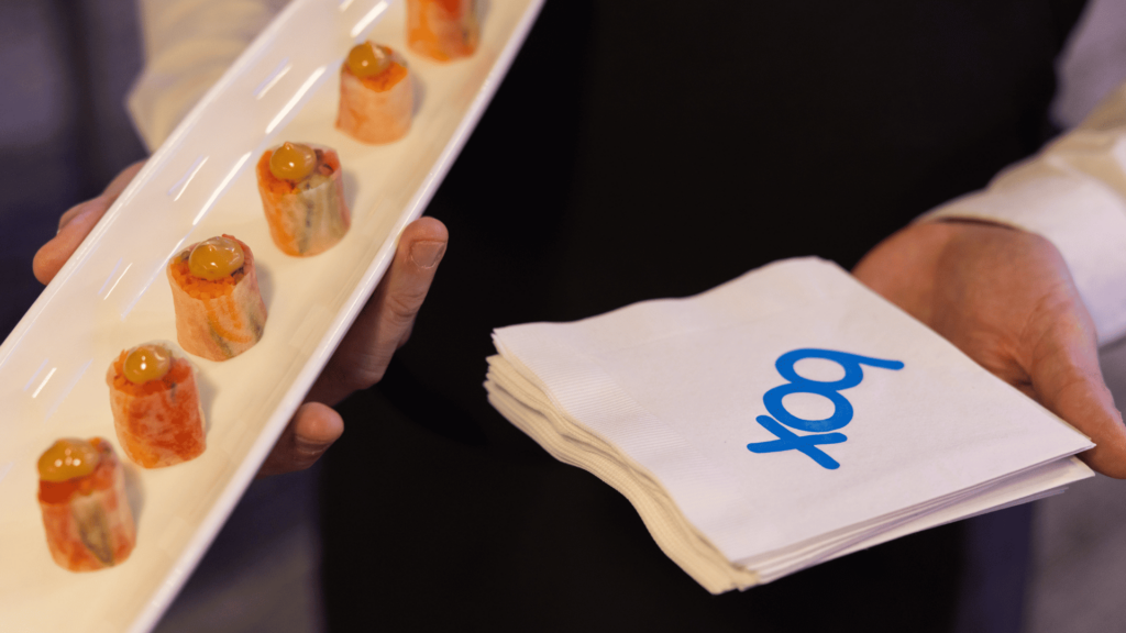 A person holding a plate of food and a napkin