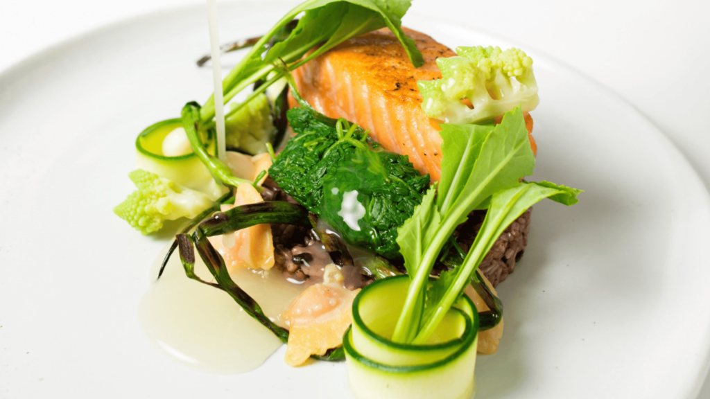 a dish on a plate with vegetables and meat