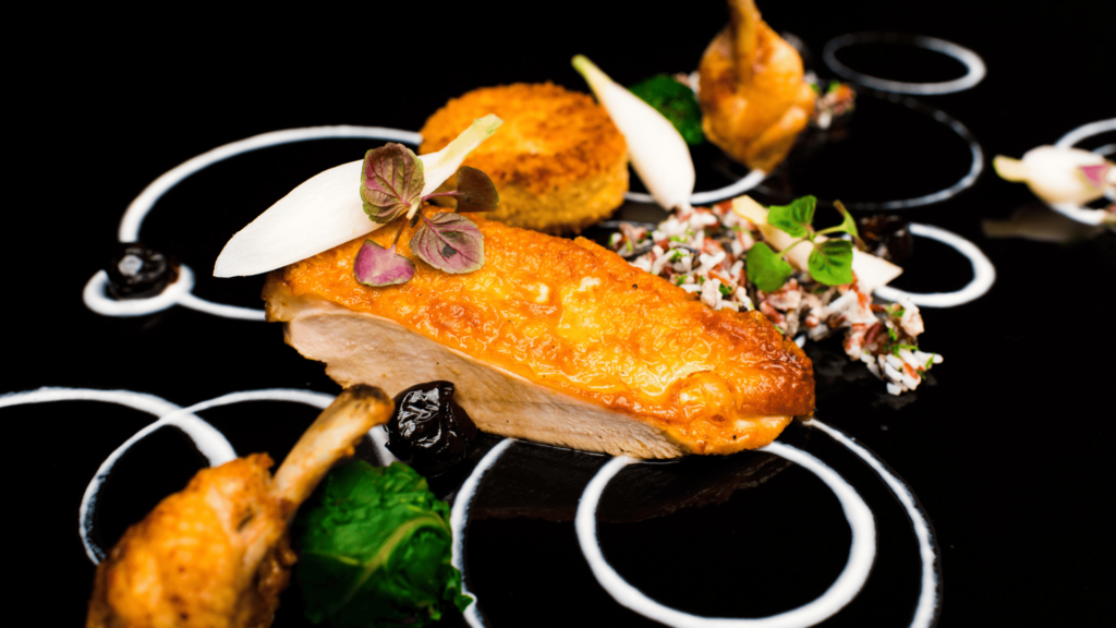 A piece of meat on a black decorated plate