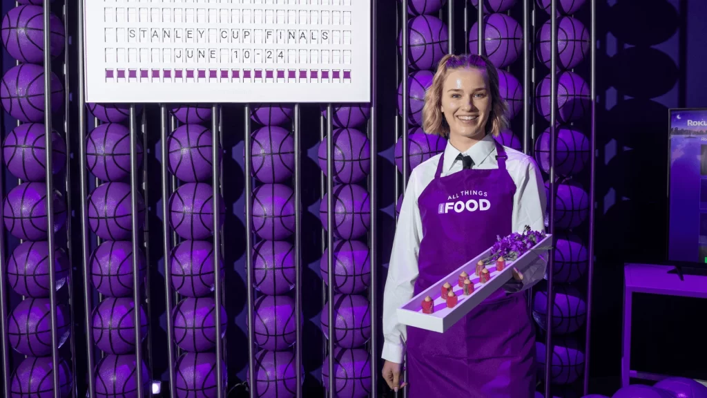 A lady standing in front of a bunch of purple balls