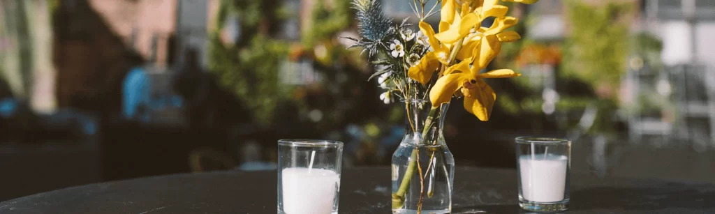 Some candles and a flower sitting on a table with a blurred backround